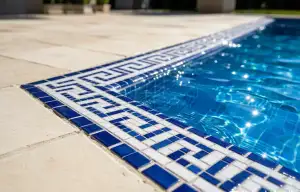 Close-up of swimming pool waterline with decorative Greek key mosaic border