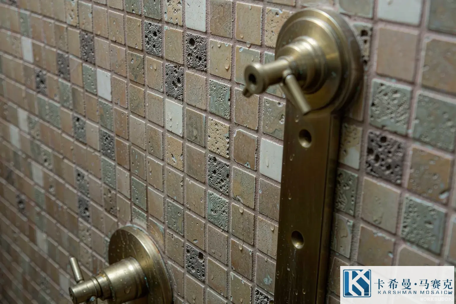 Close detail of glass mosaic tiles inside a shower niche with a brushed brass fixture and water droplets